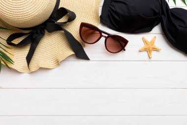 Woman swimwear and beach accessories flat lay top view on colored background Summer travel concept. bikini swimsuit, straw hat and seasheels. Copy space Top view.