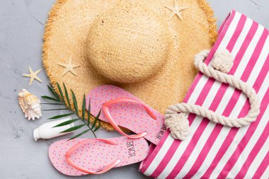 Plaj aksesuarları renkli arka plan yaz seyahati konseptinde düz bir görünüm sergiliyordu. İçinde deniz yıldızı ve deniz kabuğu olan bir çanta. Üst görünüm.