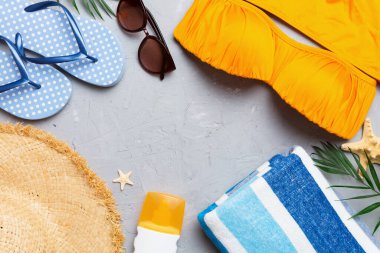 Woman swimwear and beach accessories flat lay top view on colored background Summer travel concept. bikini swimsuit, straw hat and seasheels. Copy space Top view.