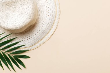 Yaz tatili. Hasır şapka ve tropikal yapraklı yaz konsepti. Düz konum, üst görünüm, kopyalama alanı.