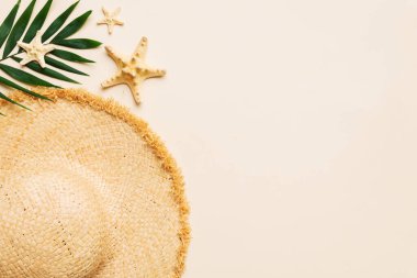 Summer holidays. Summer concept with straw hat and tropical leaf. Flat lay, top view, copy space.