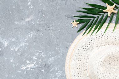 Summer holidays. Summer concept with straw hat and tropical leaf. Flat lay, top view, copy space.