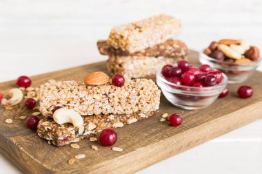 Arka planda çeşitli granola barlar var. Mısır gevreği gofretleri. Yulaf, fındık ve böğürtlenli kahvaltı barları, yakın çekim. Süper yiyecek konsepti.
