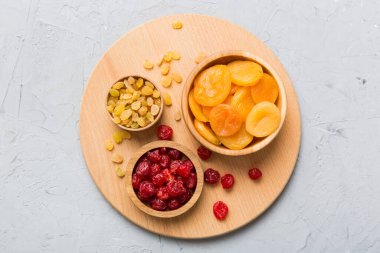 Masa arkasında farklı kurumuş meyveler olan bir kase, üst manzara. Kopyalama alanı olan sağlıklı yaşam biçimi.