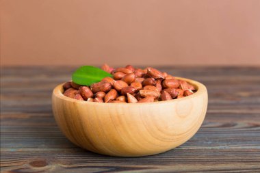 Fresh healthy peanuts in bowl on colored table background. Top view Healthy eating bertholletia concept. Super foods.