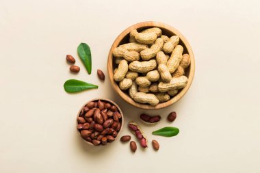 Fresh healthy peanuts in bowl on colored table background. Top view Healthy eating bertholletia concept. Super foods.