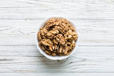 Fresh healthy walnuts in bowl on colored table background. Top view Healthy eating bertholletia concept. Super foods.