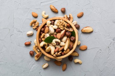 mixed nuts in bowl. Mix of various nuts on colored background. pistachios, cashews, walnuts, hazelnuts, peanuts and brazil nuts.