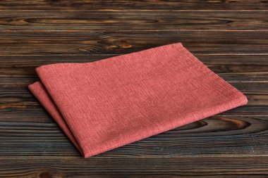 top view with red empty kitchen napkin isolated on table background. Folded cloth for mockup with copy space, Flat lay. Minimal style.