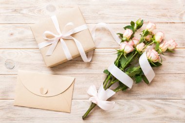 Pembe gül çiçekli tasarım konsepti ve renkli masa arkası manzaralı hediye kutusu. Mutlu Noeller, Anneler Günü, doğum günü konsepti. Romantik düz konum.