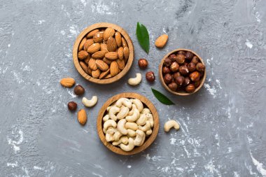 Renkli masadaki ahşap kasede fındık çeşitleri. Ceviz, fındık, ceviz, badem. Fındık Üst görünümü ile kopyalama alanını karıştır.