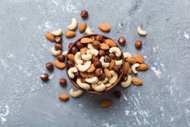 Renkli masadaki ahşap kasede fındık çeşitleri. Ceviz, fındık, ceviz, badem. Fındık Üst görünümü ile kopyalama alanını karıştır.