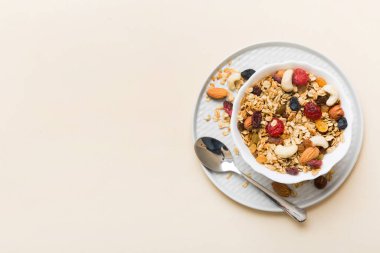 Sağlıklı bir kahvaltı hazırlıyorum. Bir kasede çeşitli kurutulmuş meyve ve fındıklı granola. Sağlıklı tatlı kavramı. Düz konum, kopyalama alanı olan üst görünüm.