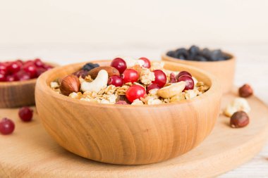 Sağlıklı bir kahvaltı hazırlıyorum. Bir kasede çeşitli kurutulmuş meyve ve fındıklı granola. Sağlıklı tatlı kavramı. Düz konum, kopyalama alanı olan üst görünüm.