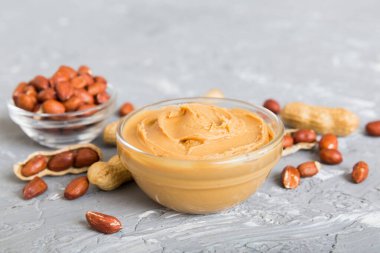 Arka planda bir kase fıstık ezmesi ve fıstık. Kopyalama alanı olan üst görünüm. Küçük kasede kremalı fıstıklı makarna.