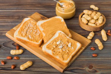 Fıstık ezmeli sandviç ya da arka planda kızarmış ekmek. Kahvaltı. Vejetaryen yemeği. Amerikan mutfağının üst görünümü kopyalama alanı.