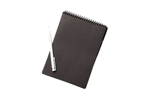 閉じた螺旋状の黒紙カバーノートブックのトップビューと白の背景に孤立した鉛筆 — ストック写真
