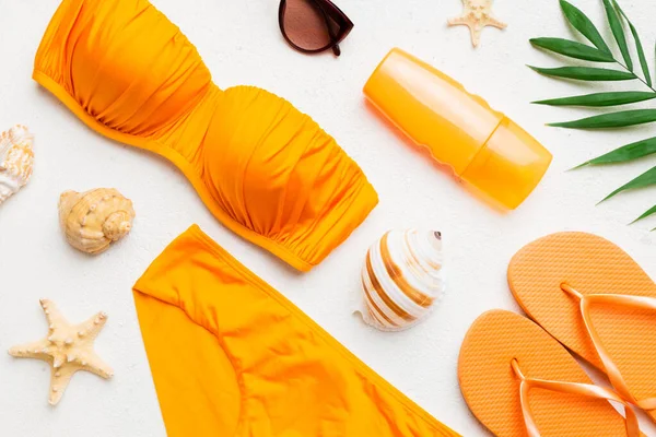 stock image Woman swimwear and beach accessories flat lay top view on colored background Summer travel concept. bikini swimsuit, straw hat and seasheels. Copy space Top view.