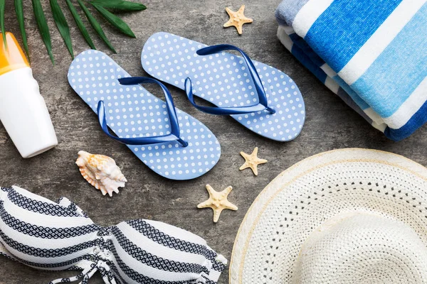 Woman swimwear and beach accessories flat lay top view on colored background Summer travel concept. bikini swimsuit, straw hat and seasheels. Copy space Top view.