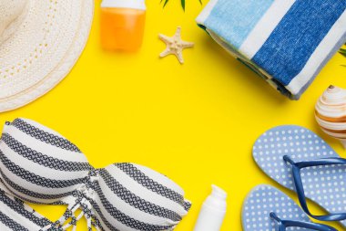 Woman swimwear and beach accessories flat lay top view on colored background Summer travel concept. bikini swimsuit, straw hat and seasheels. Copy space Top view.