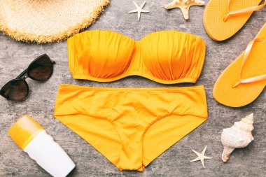 Kadın mayo ve plaj aksesuarları renkli arka plan yaz seyahati konseptine düz bir görünüm kazandırıyordu. Bikini mayo, hasır şapka ve deniz topuklu ayakkabı. Üst görünümü kopyala.
