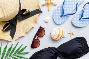 Kadın mayo ve plaj aksesuarları renkli arka plan yaz seyahati konseptine düz bir görünüm kazandırıyordu. Bikini mayo, hasır şapka ve deniz topuklu ayakkabı. Üst görünümü kopyala.