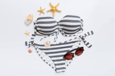 Kadın mayo ve plaj aksesuarları renkli arka plan yaz seyahati konseptine düz bir görünüm kazandırıyordu. Bikini mayo, hasır şapka ve deniz topuklu ayakkabı. Üst görünümü kopyala.