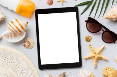 Renkli arka planda tablet ve plaj aksesuarlarıyla düz kompozisyon. Boş ekran ile tablet bilgisayarı kopyalama alanı ile maket.