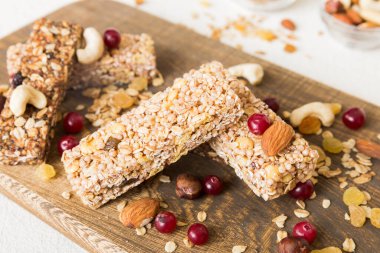Arka planda çeşitli granola barlar var. Mısır gevreği gofretleri. Yulaf, fındık ve böğürtlenli kahvaltı barları, yakın çekim. Süper yiyecek konsepti.