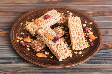 Arka planda çeşitli granola barlar var. Mısır gevreği gofretleri. Yulaf, fındık ve böğürtlenli kahvaltı barları, yakın çekim. Süper yiyecek konsepti.