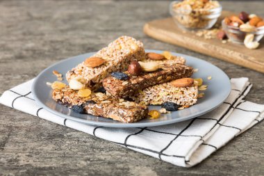 Arka planda çeşitli granola barlar var. Mısır gevreği gofretleri. Yulaf, fındık ve böğürtlenli kahvaltı barları, yakın çekim. Süper yiyecek konsepti.