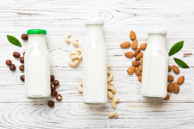 Masa arkasında çeşitli vejetaryen süt bademi, kaju fıstığı seti ya da koleksiyonu. Vejetaryen bitkisi sütü ve malzemeleri, üst görünüm.