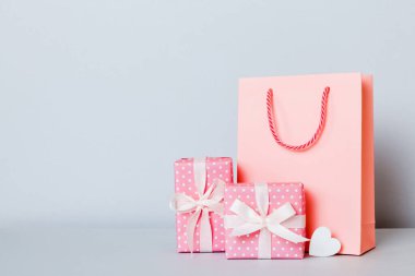 Shopping bag with gift box on colored background perspecrive view. Space for text holiday concept.