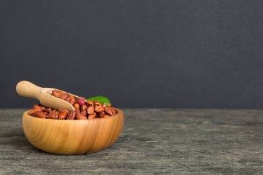 Fresh healthy peanuts in bowl on colored table background. Top view Healthy eating bertholletia concept. Super foods.