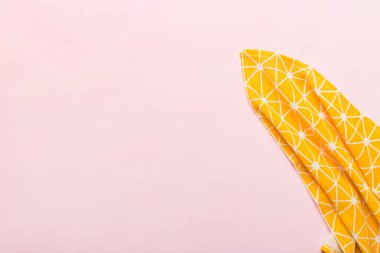 top view with yellow empty kitchen napkin isolated on table background. Folded cloth for mockup with copy space, Flat lay. Minimal style.