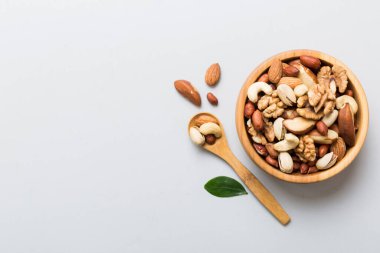 mixed nuts in bowl. Mix of various nuts on colored background. pistachios, cashews, walnuts, hazelnuts, peanuts and brazil nuts.