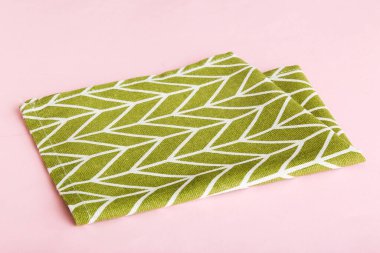 top view with green kitchen napkin isolated on table background. Folded cloth for mockup with copy space, Flat lay. Minimal style.