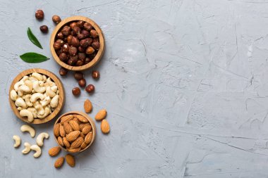 Renkli masadaki ahşap kasede fındık çeşitleri. Ceviz, fındık, ceviz, badem. Fındık Üst görünümü ile kopyalama alanını karıştır.