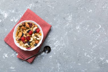 Sağlıklı bir kahvaltı hazırlıyorum. Bir kasede çeşitli kurutulmuş meyve ve fındıklı granola. Sağlıklı tatlı kavramı. Düz konum, kopyalama alanı olan üst görünüm.