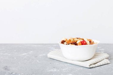 Sağlıklı bir kahvaltı hazırlıyorum. Bir kasede çeşitli kurutulmuş meyve ve fındıklı granola. Sağlıklı tatlı kavramı. Düz konum, kopyalama alanı olan üst görünüm.
