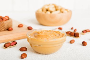 Arka planda bir kase fıstık ezmesi ve fıstık. Kopyalama alanı olan üst görünüm. Küçük kasede kremalı fıstıklı makarna.