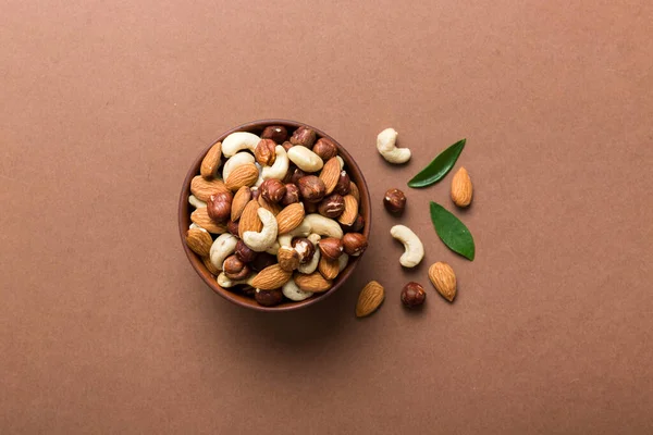 Renkli masadaki ahşap kasede fındık çeşitleri. Ceviz, fındık, ceviz, badem. Fındık Üst görünümü ile kopyalama alanını karıştır.