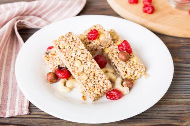 Arka planda çeşitli granola barlar var. Mısır gevreği gofretleri. Yulaf, fındık ve böğürtlenli kahvaltı barları, yakın çekim. Süper yiyecek konsepti.