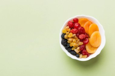 Masa arkasında farklı kurumuş meyveler olan bir kase, üst manzara. Kopyalama alanı olan sağlıklı yaşam biçimi.