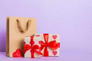 Shopping bag with gift box on colored background perspecrive view. Space for text holiday concept.