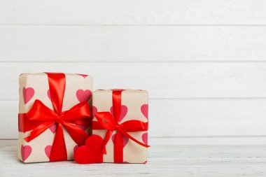 gift box with red bow and red heart on colored background. Perspective view. Flat lay.