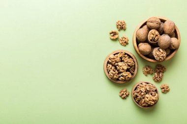 Fresh healthy walnuts in bowl on colored table background. Top view Healthy eating bertholletia concept. Super foods.