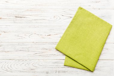 top view with green kitchen napkin isolated on table background. Folded cloth for mockup with copy space, Flat lay. Minimal style.