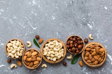 Renkli masadaki ahşap kasede fındık çeşitleri. Ceviz, fındık, ceviz, badem. Fındık Üst görünümü ile kopyalama alanını karıştır.