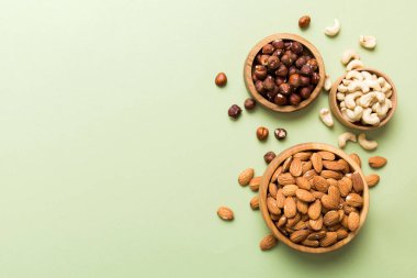 Renkli masadaki ahşap kasede fındık çeşitleri. Ceviz, fındık, ceviz, badem. Fındık Üst görünümü ile kopyalama alanını karıştır.